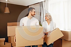 Moving House. Man And Woman Holding Boxes