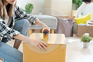 Moving house, relocation. Couple help set and move furniture for new apartment, inside the room was a cardboard box contain