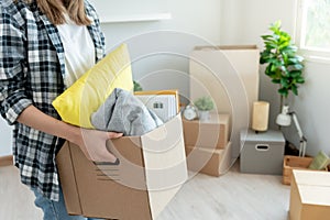 Moving house, relocation. Woman hold carton box contain equipment for new condominium, inside the room was a cardboard box