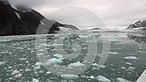 Moving Ice Floes on background of mountain on water of Arctic Ocean in Svalbard.