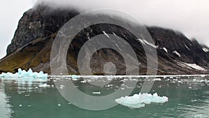 Moving Ice Floes on background of mountain on water of Arctic Ocean in Svalbard.