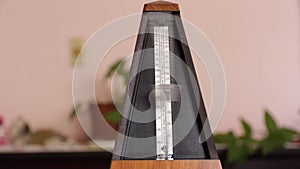 A moving metronome with blurred background.