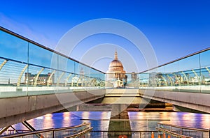 Moving people alonf Millennium Bridge in London. Night view of S