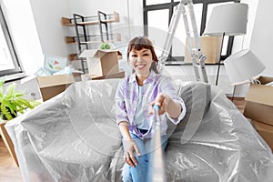 smiling asian woman taking selfie at new home