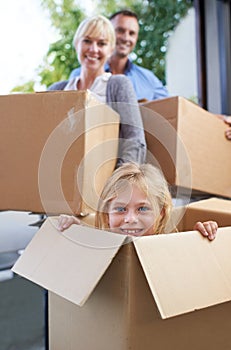 Moving, portrait and girl in box with parent, fun in new home and happy package with mortgage. Mother, father and