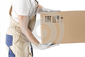 Moving service worker holds cardboard box close-up on white background. Relocation man in uniform with box