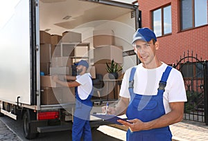 Moving service workers outdoors, unloading boxes and checking list