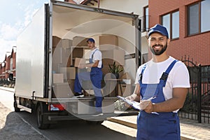 Moving service workers outdoors, unloading boxes and checking list