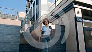 Moving shot happy confident African American business woman girl lady ethnic female businesswoman walking in city walk