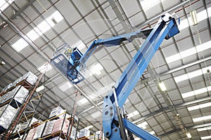 Moving stock in a warehouse with a cherry picker, low angle photo