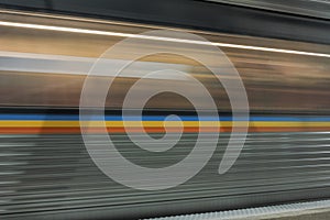 Moving subway train passing quickly in underground station