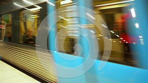 Moving subway train. Underground train departs from modern subway station. Wagons with people following its route