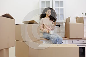 moving to new apartment relocation. happy young woman, packing boxes with personal belongings,