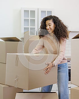 moving to new apartment relocation. happy young woman packing boxes with personal belongings