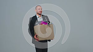Moving to new office. Male manager employee businessman in suit walks holding cardboard box with belongings. Slow motion