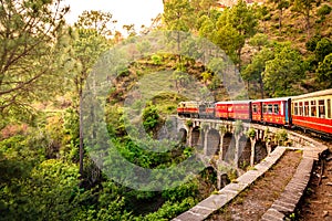 moving Toy train on arch bridge over mountain slopes of Shimla to Kalka photo