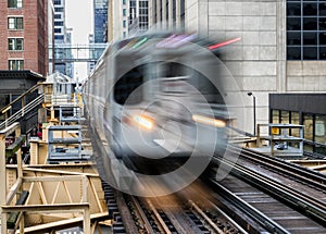 Moving Train on elevated tracks within buildings at the Loop, Glass and Steel bridge between buildings - Chicago City Center - Lon