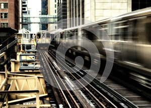 Moving Train on elevated tracks within buildings at the Loop, Glass and Steel bridge between buildings - Chicago City Center - Lon