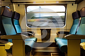 Moving train four empty coach seats blue upholstery swiss sbb rail network