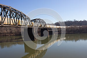 Conmovedor el tren sobre el vias ferreas puente a través de lunes un rio 