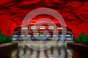 Moving train Stockholm metro or tunnelbana station Solna Centrum with fire like wall designs photo