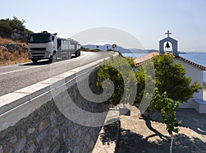 A moving truck and View of the Cycladic style Greek Church of Evia in Greece on a Sunny day