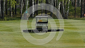 Mower work in the grass at the edge of a Scottish golf course. Machine for turf on Golf