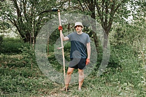 mowing the grass traditional old-fashioned way with the hand scythe on the household village farm