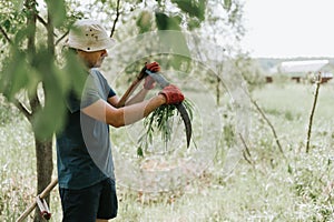 mowing grass traditional old-fashioned way with hand scythe on household village farm. young mature farmer man