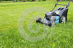 Mowing lawns. Lawn mower on green grass. mower grass equipment. mowing gardener care work tool close up view sunny day