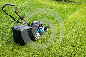 Mowing lawns. Lawn mower on green grass. mower grass equipment. mowing gardener care work tool close up view sunny day.