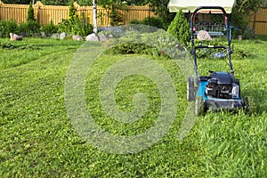 Mowing lawns Lawn mower on green grass mower grass equipment mowing gardener care work tool close up view sunny day
