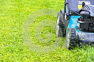 Mowing lawns, Lawn mower on green grass, mower grass equipment, mowing gardener care work tool, close up view, sunny day. photo