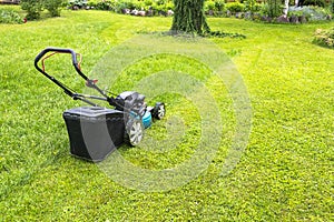 Mowing lawns, Lawn mower on green grass, mower grass equipment, mowing gardener care work tool, close up view, sunny day