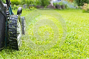 Mowing lawns, Lawn mower on green grass, mower grass equipment, mowing gardener care work tool, close up view, sunny day