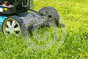 Mowing lawns, Lawn mower on green grass, mower grass equipment, mowing gardener care work tool, close up view, sunny day photo