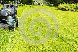 Mowing lawns, Lawn mower on green grass, mower grass equipment, mowing gardener care work tool, close up view, sunny day