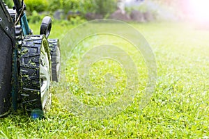 Mowing lawns, Lawn mower on green grass, mower grass equipment, mowing gardener care work tool, close up view, sunny day. Soft