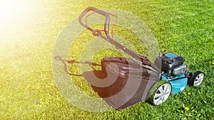 Mowing lawns, Lawn mower on green grass, mower grass equipment, mowing gardener care work tool, close up view, sunny day. Soft lig