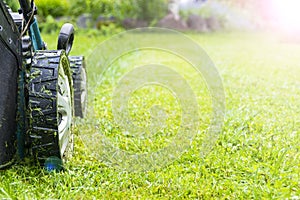 Mowing lawns, Lawn mower on green grass, mower grass equipment, mowing gardener care work tool, close up view, sunny day. Soft photo