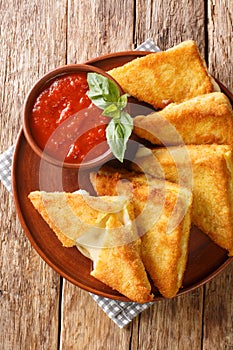 Mozzarella in Carrozza Fried Italian Sandwiches with sauce closeup in the plate. Vertical top view photo