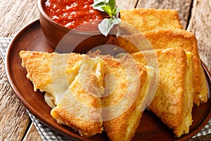 Mozzarella in carrozza is an Italian cheese sandwich made by breading and frying mozzarella-stuffed bread closeup on the table. photo