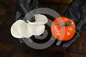 Mozzarella cheese and fresh tomato in the hands