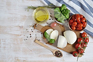 Mozzarella cheese with red tomatoes and basil leaves, pepper, olive oil