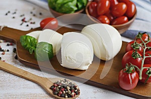 Mozzarella cheese with red tomatoes and basil leaves, pepper, olive oil