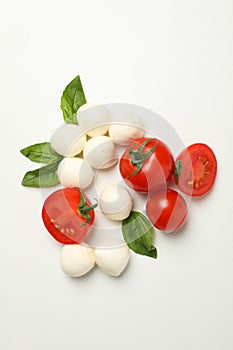 Mozzarella cheese, tomato and basil on white background