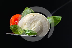 Mozzarella cheese with tomato cherry slices and green basil