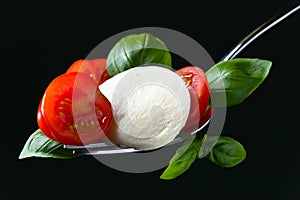Mozzarella cheese with tomato cherry slices and green basil