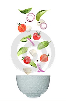 Mozzarella cheese, tomatoes, onion and basil leaves falling into bowl on background