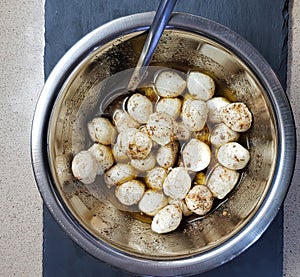 Mozzarella Ñheese balls in olive oil with Provencal herbs in a bowl